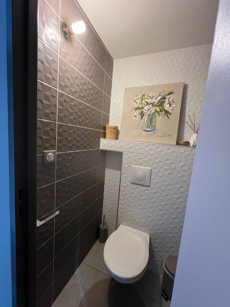 Applique murale en pâte auto-durcissante blanche posée dans des toilettes modernes.