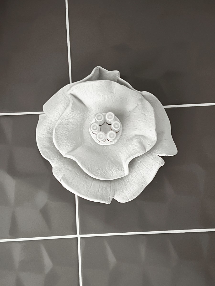 Applique murale en pâte auto-durcissante blanche posée dans des toilettes modernes