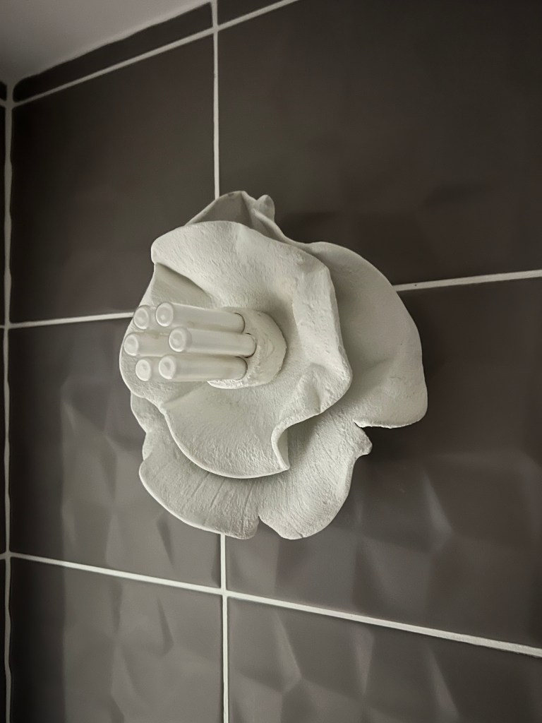 Applique murale en pâte auto-durcissante blanche posée dans des toilettes modernes.